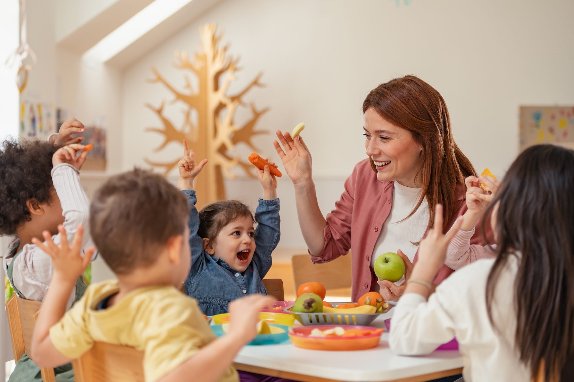 Educator sharing fruit with children at a childcare centre
